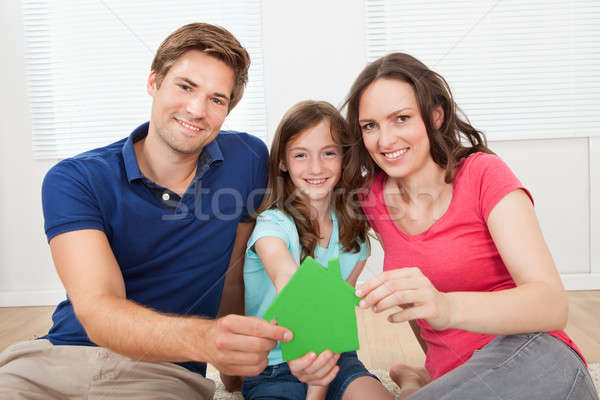 Happy Family Holding Green House Model At Home Stock photo © AndreyPopov