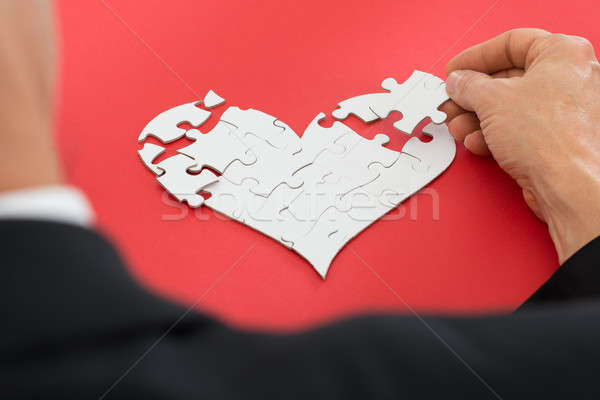 Person Solving Heartshape Jigsaw Puzzle Stock photo © AndreyPopov