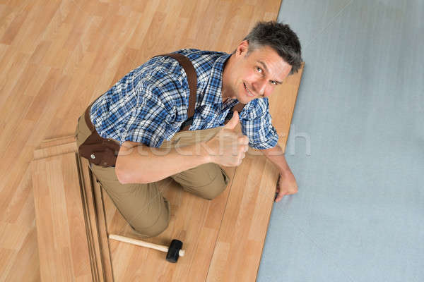 Happy Worker Assembling New Laminate Floor Stock photo © AndreyPopov