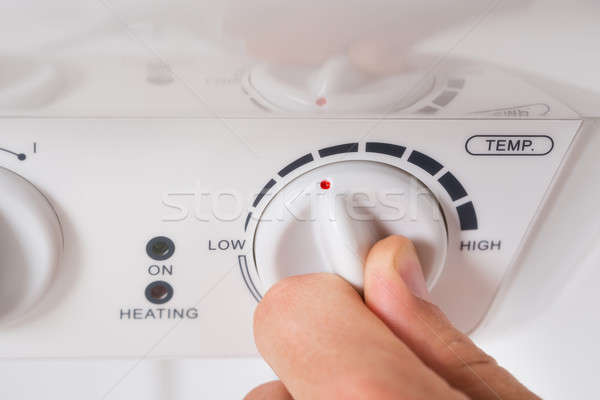 Stock photo: Person Turning The Knob Of Electric Boiler