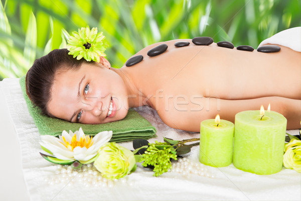 Happy Woman Receiving Hot Stone Therapy In Spa Stock photo © AndreyPopov