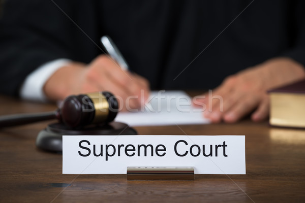 Supreme Court Nameplate With Judge Writing On Paper Stock photo © AndreyPopov