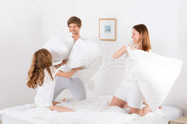 Famille bataille d'oreillers lit famille heureuse chambre homme [[stock_photo]] © AndreyPopov