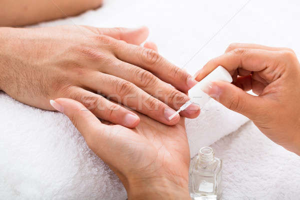 Manicurist Applying Moisturizing Oil On Person's Hand Stock photo © AndreyPopov