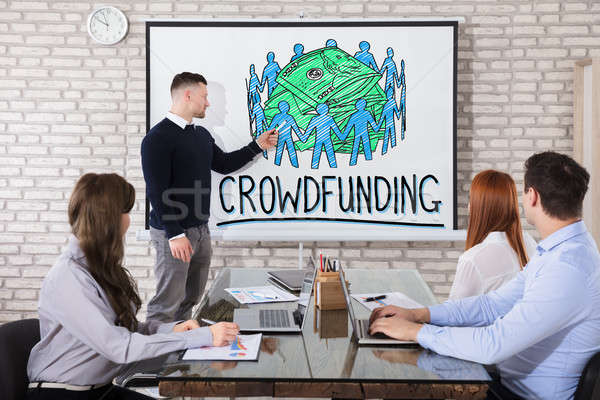 Businessman Showing Crowd Funding Concept In Office Stock photo © AndreyPopov