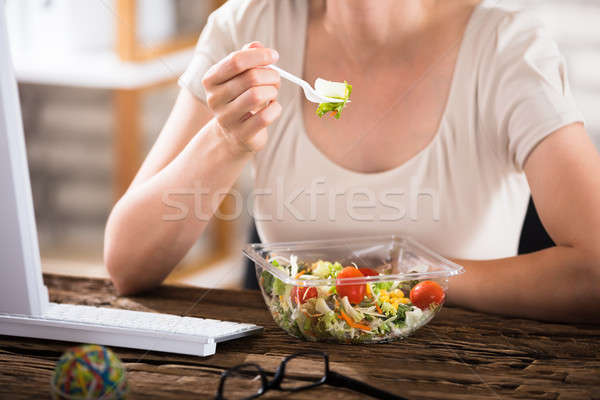 Mujer comer ensalada primer plano pausa para el almuerzo escritorio Foto stock © AndreyPopov