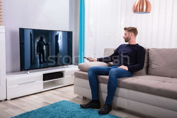 Man Watching Suspense Movie On Television Stock photo © AndreyPopov