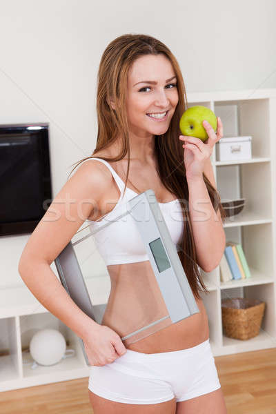 Portrait Of Beautiful Young Woman Holding A Weighing Scale And An Apple Stock photo © AndreyPopov