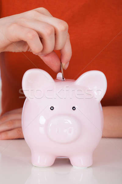 Stock photo: Hand Inserting Coin In Piggybank