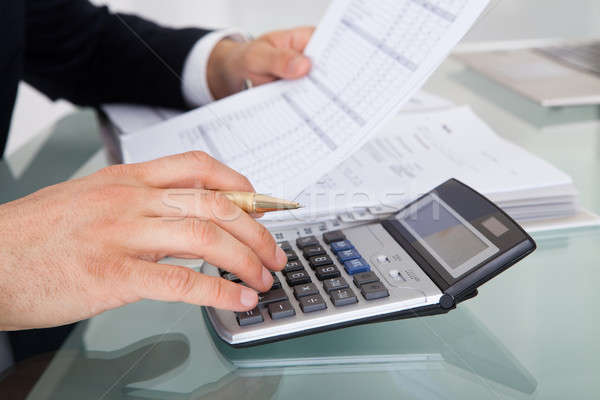 Stock photo: Businessman Holding Calculating Expense In Office