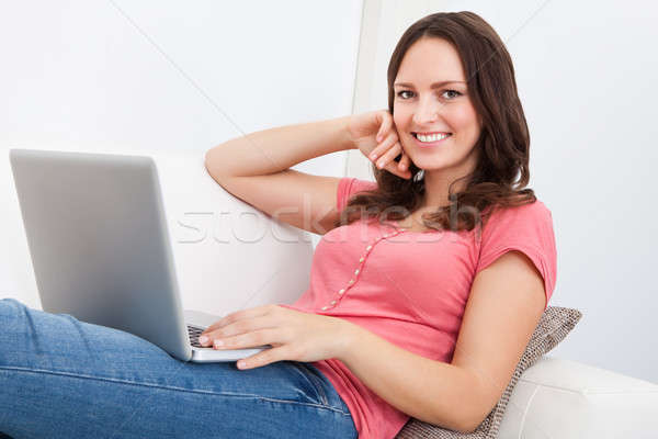 Woman Sitting On Couch Using Laptop Stock photo © AndreyPopov