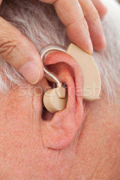 Doctor Inserting Hearing Aid In Senior Man's Ear Stock photo © AndreyPopov