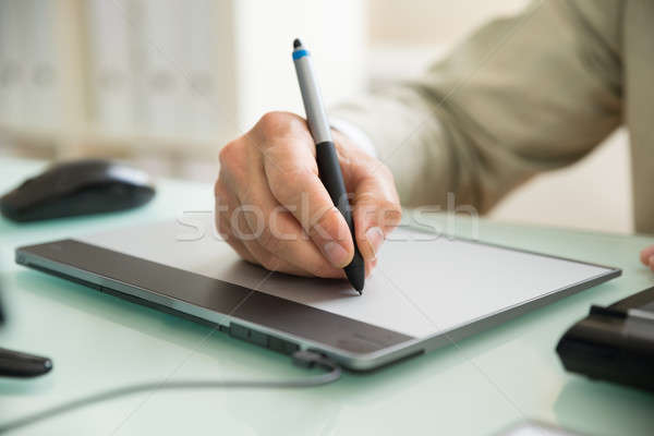 Businessman Writing On Graphic Tablet Stock photo © AndreyPopov