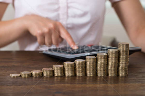 üzletasszony egymásra pakolva érmék közelkép számológép asztal Stock fotó © AndreyPopov