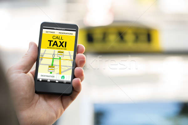 Person Booking Taxi On Smart Phone Stock photo © AndreyPopov