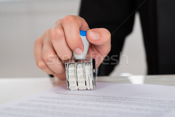 Businesswoman Stamping Contract Paper At Desk Stock photo © AndreyPopov