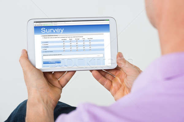 Man Holding Mobile Phone Showing Survey Form Stock photo © AndreyPopov