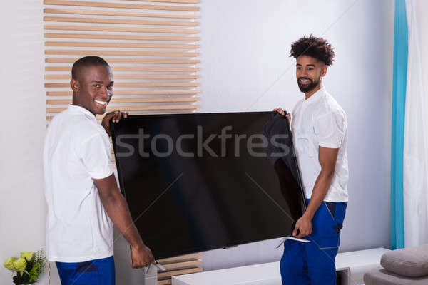 Young Movers Placing Television In The Living Room Stock photo © AndreyPopov