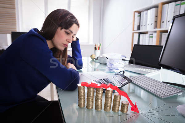 Red Arrow Over Decreasing Stacked Coins Stock photo © AndreyPopov