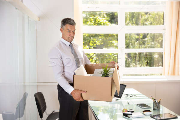 Unhappy Businessman Carrying Belongings In Cardboard Box Stock photo © AndreyPopov