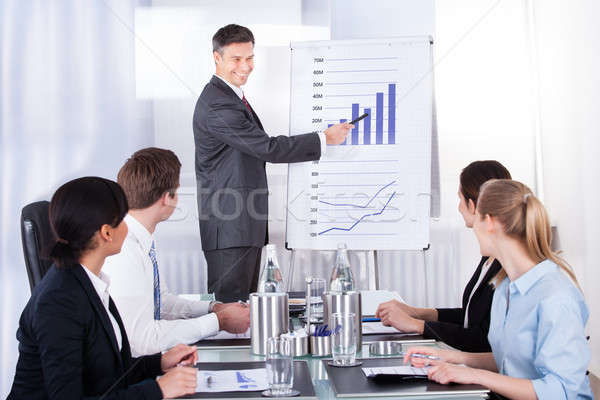 üzletember magyaráz grafikon érett kollégák ül Stock fotó © AndreyPopov