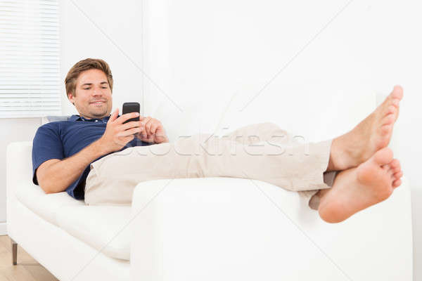 человека обмен сообщениями диван домой Сток-фото © AndreyPopov
