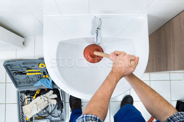 Male Plumber Using Plunger In Bathroom Sink Stock photo © AndreyPopov