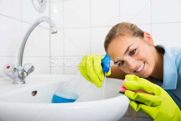 Smiling Woman Cleaning The Basin With Spray Bottle Stock photo © AndreyPopov