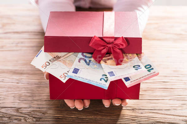 Woman Holding Gift Box Of Us Euro Bills Stock photo © AndreyPopov