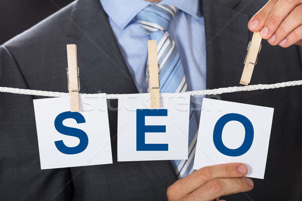 Businessman Pinning SEO Cards On Clothesline Stock photo © AndreyPopov