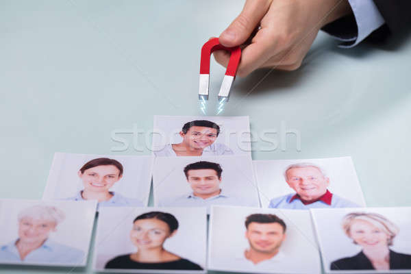 Hand With Horseshoe Magnet Attracting Photographs Stock photo © AndreyPopov