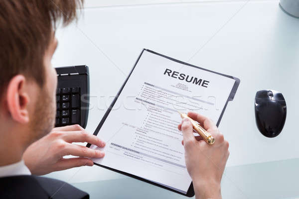 Stock photo: Businessman Analyzing Resume At Office Desk