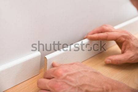 Person Applying Skirting On Wall Stock photo © AndreyPopov