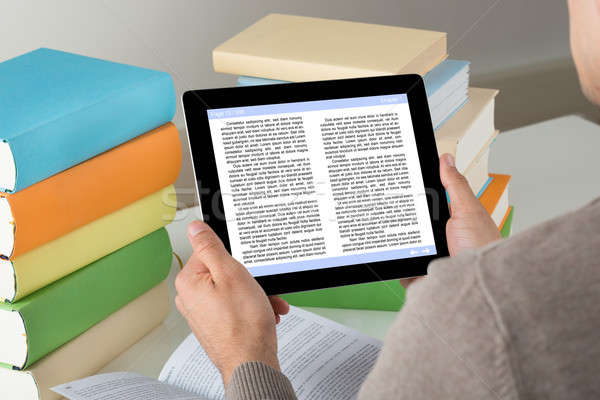 Student Holding Ereader While Studying At Desk Stock photo © AndreyPopov