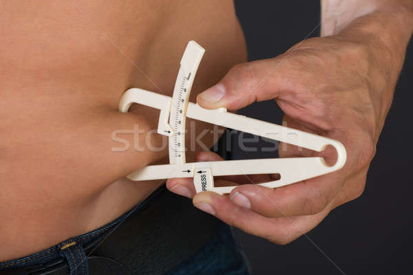 Póló nélkül férfi mér gyomor kövér közelkép Stock fotó © AndreyPopov