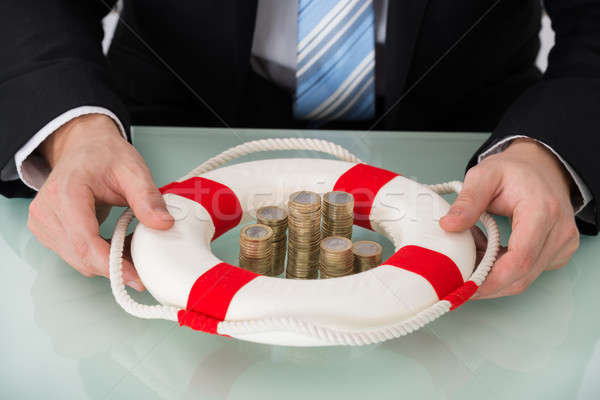 Person Holding Lifebelt With Stacked Coins Stock photo © AndreyPopov