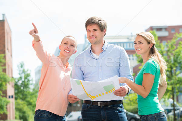 Groep vrienden naar richting glimlachend jonge Stockfoto © AndreyPopov