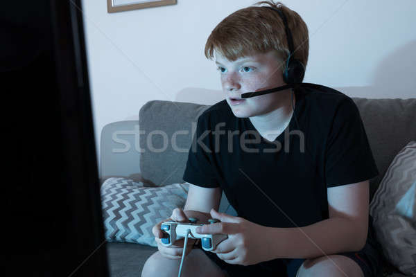 Stock photo: Boy Engrossed In Playing Videogames