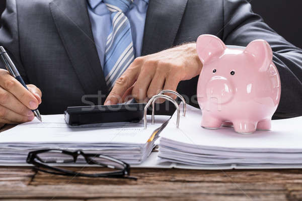 Foto stock: Empresário · piggy · bank · documentos · tabela · papel