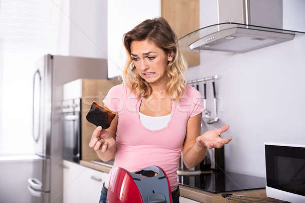 Woman Removing Slices Of Burnt Toast Stock photo © AndreyPopov