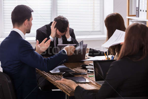 Businesspeople Blaming Depressed Male Colleague Stock photo © AndreyPopov