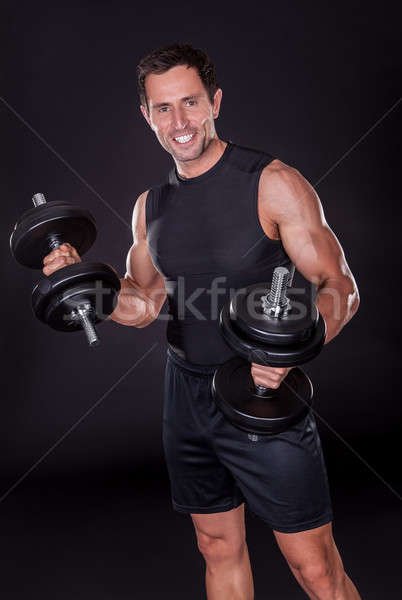 Young Attractive Man Pumping Weights Stock photo © AndreyPopov