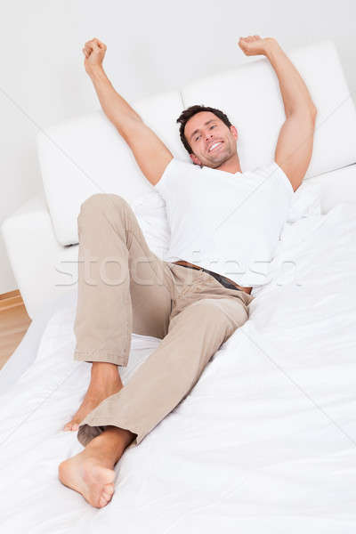 Stock photo: Man Stretching On Bed While Waking Up