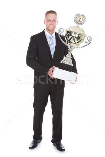 Stylish bearded businessman holding a large silver trophy Stock photo © AndreyPopov
