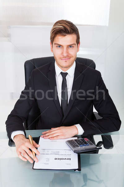 Businessman Checking Expenses At Office Desk Stock photo © AndreyPopov