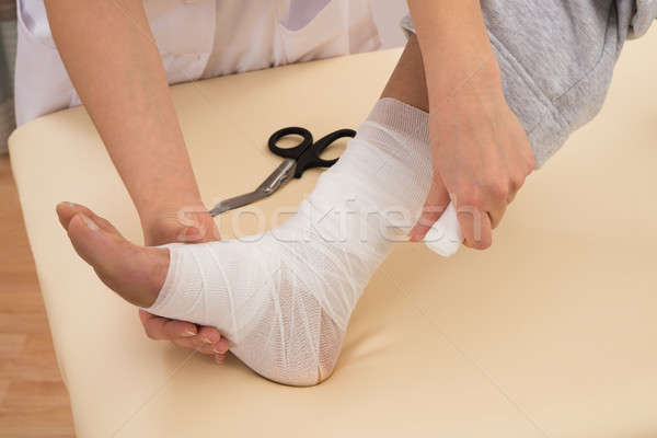 Nurse Tying Bandage On Patient's Foot Stock photo © AndreyPopov