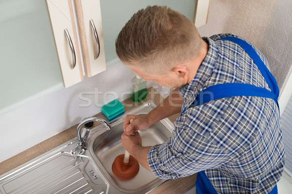 Worker Pressing Plunger In Sink Stock photo © AndreyPopov