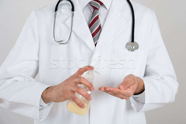 Midsection Of Doctor Using Sanitize Dispenser Stock photo © AndreyPopov