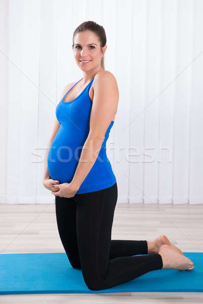 Terhes nő térdel testmozgás boldog fiatal kék Stock fotó © AndreyPopov