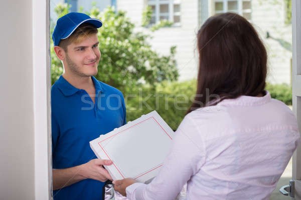 Man Delivering Pizza To Young Woman Stock photo © AndreyPopov